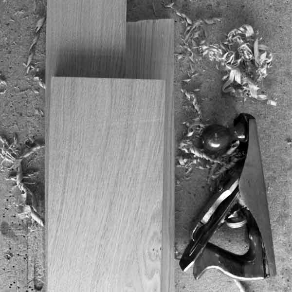A hand plane and shavings next to a piece of Sustainably sourced Oak